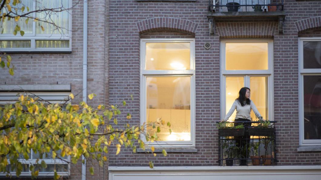 Vrouw op balkon van een woning