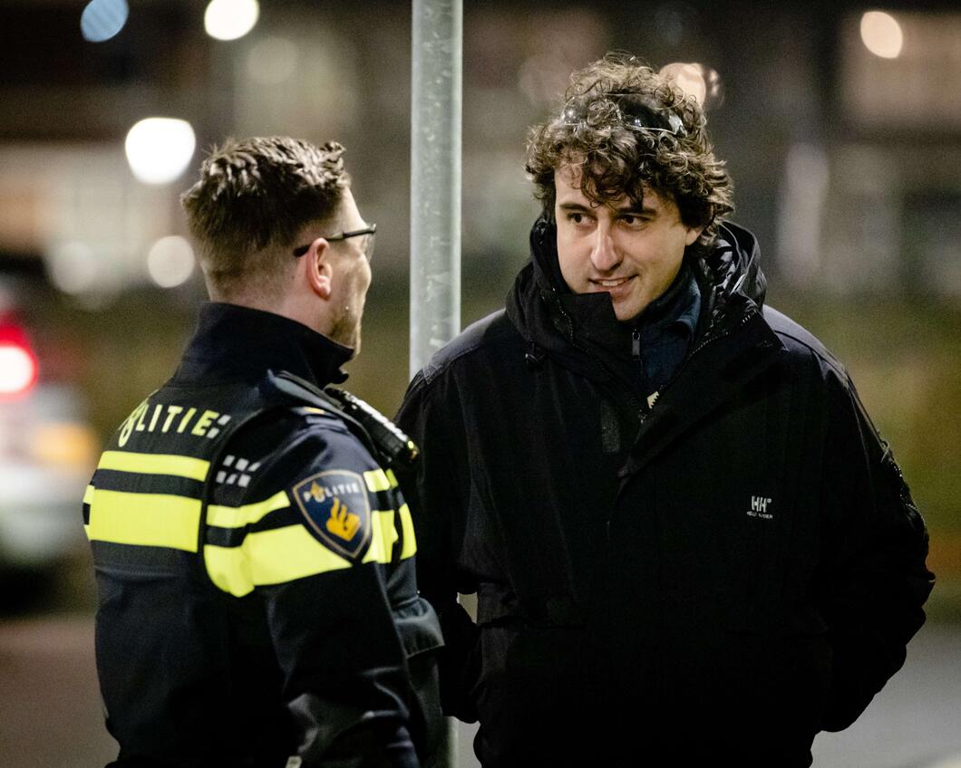 Jesse Klaver praat met een politieagent op straat tijdens oud en nieuw. 